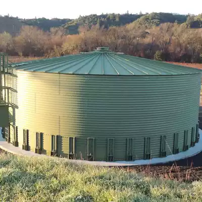 Green painted corrugated steel tank with a roof